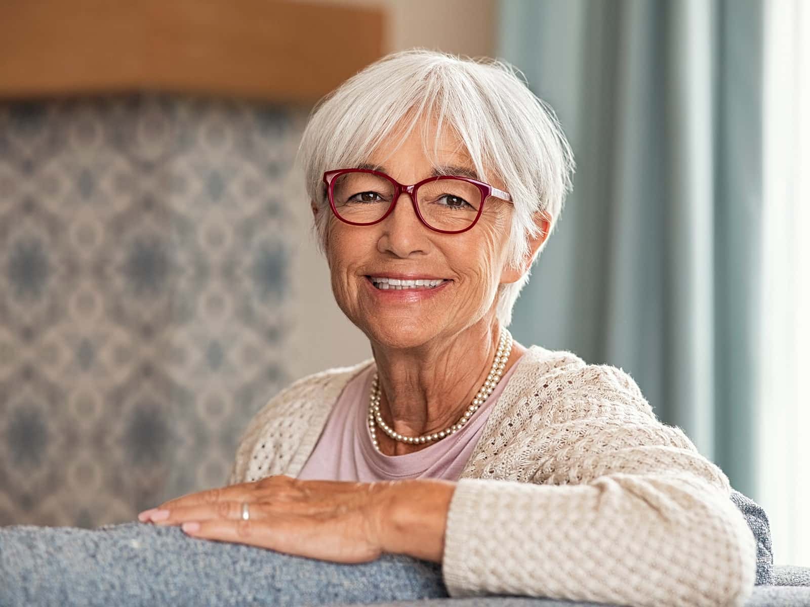 Elderly woman smiling after getting dental implants